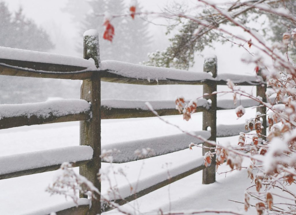 Verschneiter Holzzaun im Winter